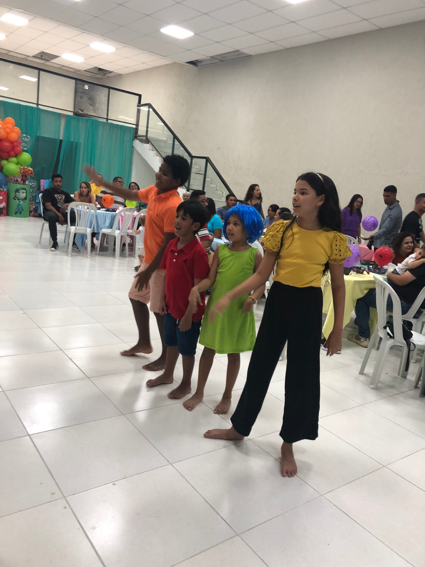 Crianças brincando no salão amplo durante festa infantil