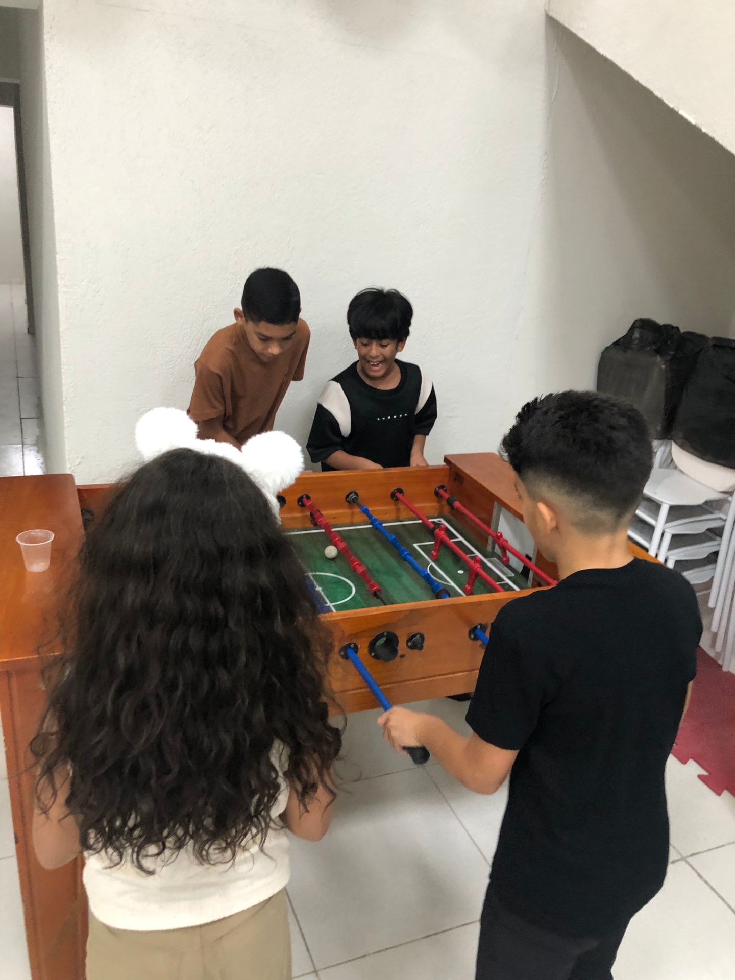 Crianças jogando pebolim no salão