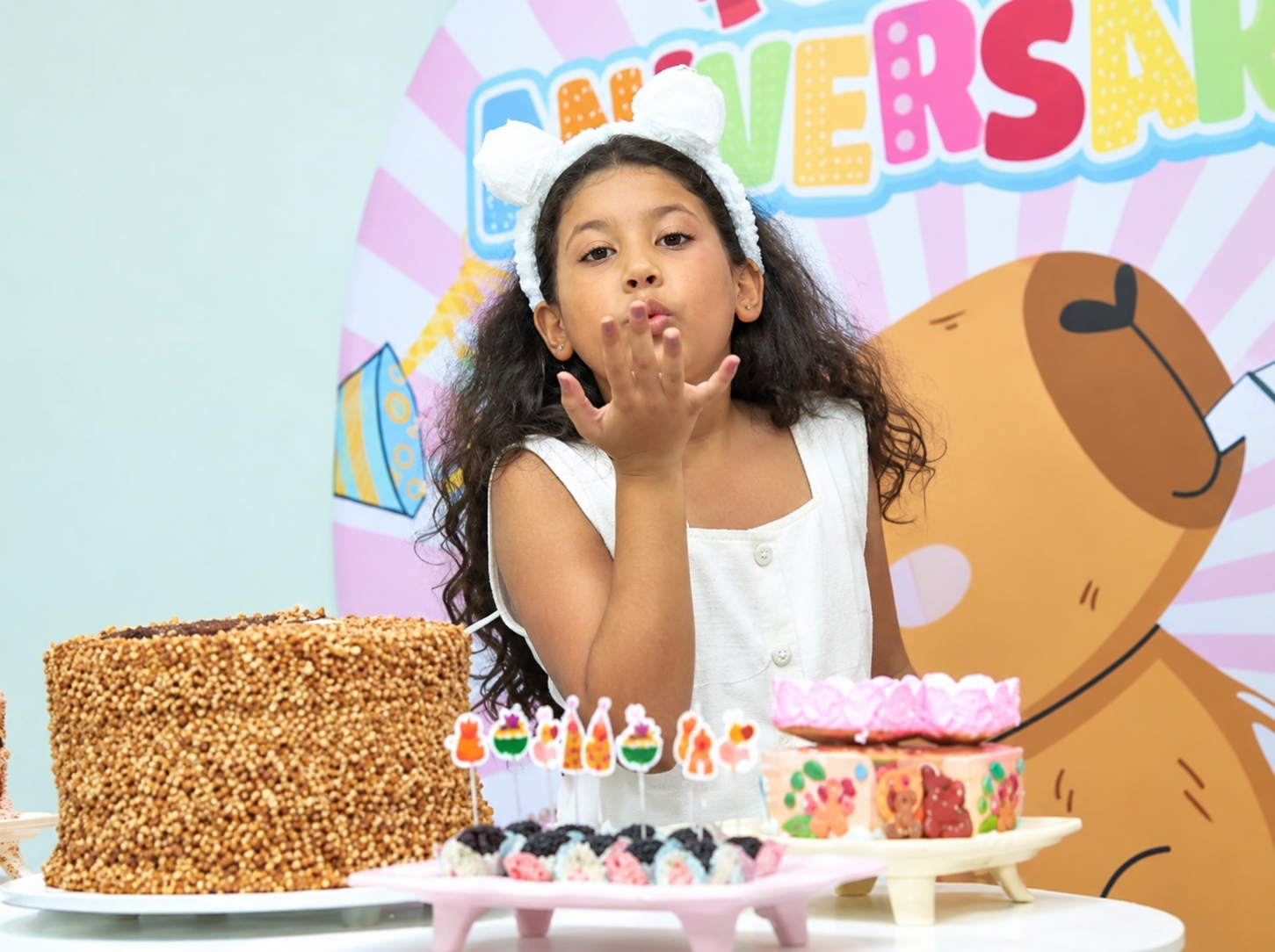 Aniversariante com mesa de doces e bolo decorado