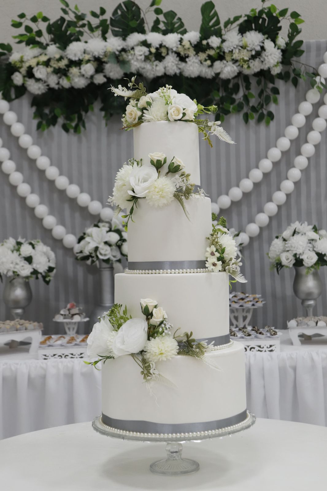 Bolo de casamento branco de quatro andares com flores